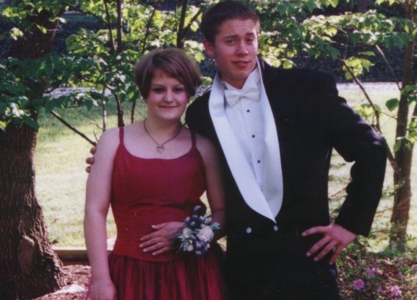 Deanna in a red dress in her 1999 prom photo with a guy in a funny looking tux. 