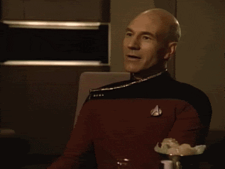Patrick Stewart as Captain Picard getting a joke and clapping