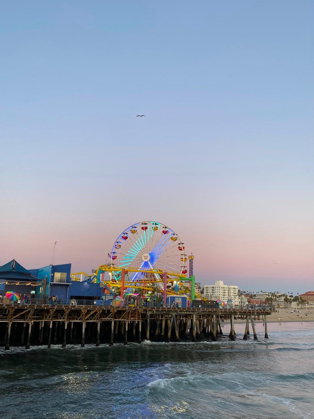 A photo of the Santa Monica boardwalk with a sunset sky in the back.