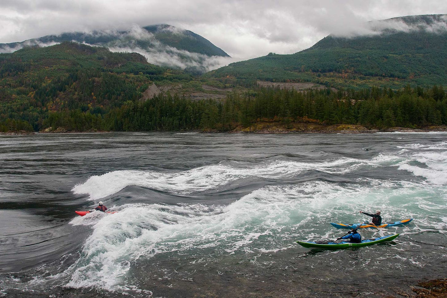 kayakers play in the rapids at Skookumchuck Narrows on a misty morning in early fall