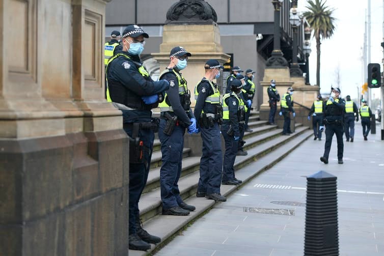 Police lined up, wearing masks