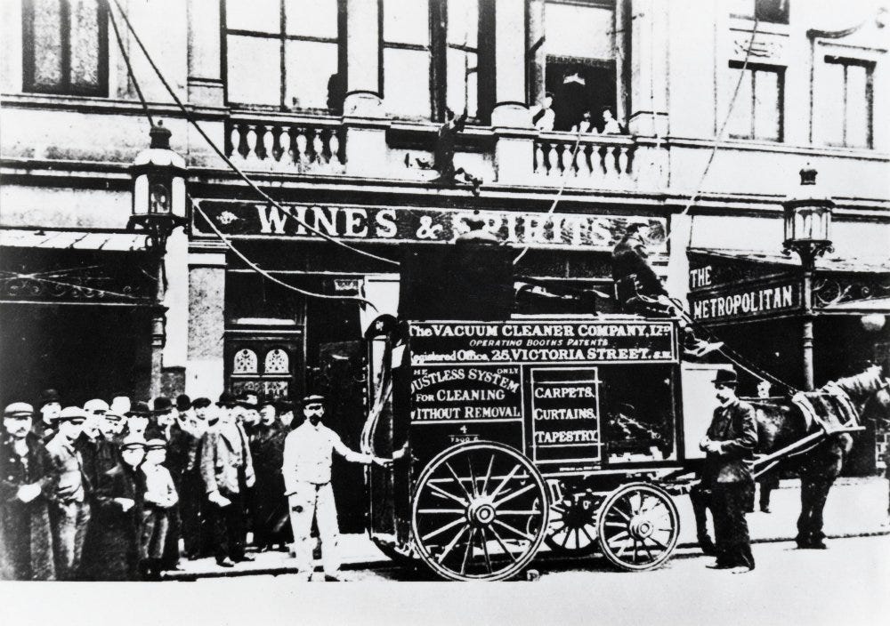 Horse-drawn vacuum cleaner with men standing by