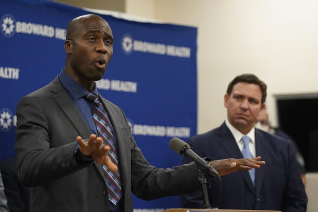 Joseph A. Ladapo, left, speaks at a news conference with Ron DeSantis, right.