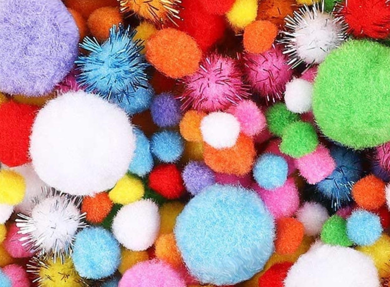an assortment of multi-colored and multi-sized pom poms