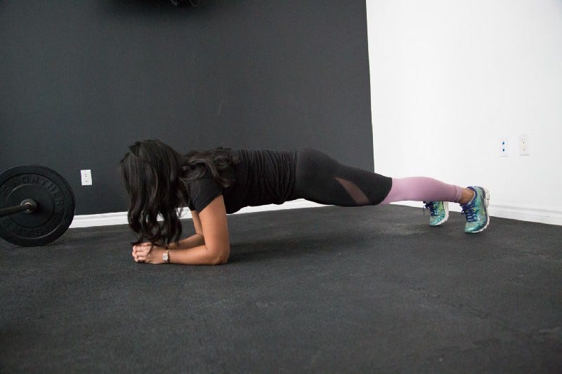 A side view of a woman doing the plank exercise