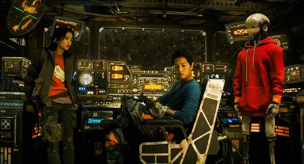 Three characters (from left to right: a woman, a man, and a robot) in a still from SPACE SWEEPERS, sitting at the cockpit of their space ship in staring at each other. 