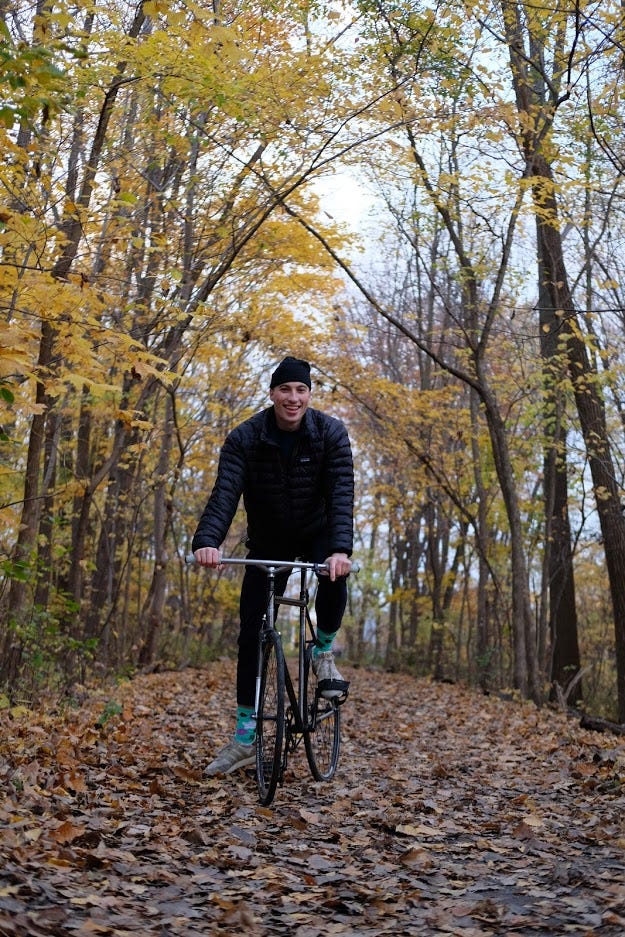 A large man sits atop his fixed gear bicycle on a nice autumnal path A large man sits atop his fixed gear bicycle on a nice autumnal path