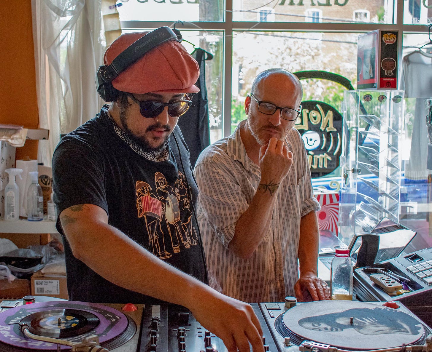 DJ C’est Funk (left) and NOLA Mix owner, Ben Epstein (right) prepare turntables for Record Store Day 2021. DJ C’est Funk (left) and NOLA Mix owner, Ben Epstein (right) prepare turntables for Record Store Day 2021.