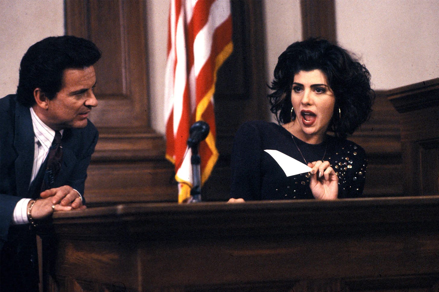 Marisa Tomei as Mona Lisa on the stand gesturing wildly as Joe Pesci looks on from the left