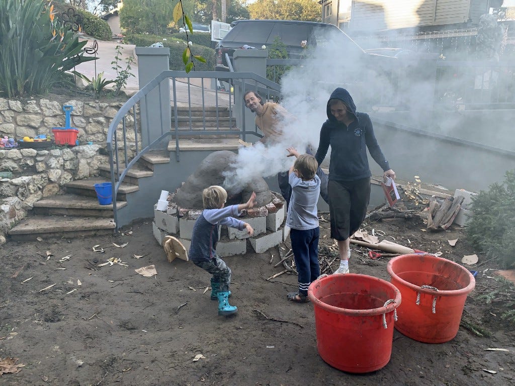 children, adults, an oven, a lot of smoke, red buckets