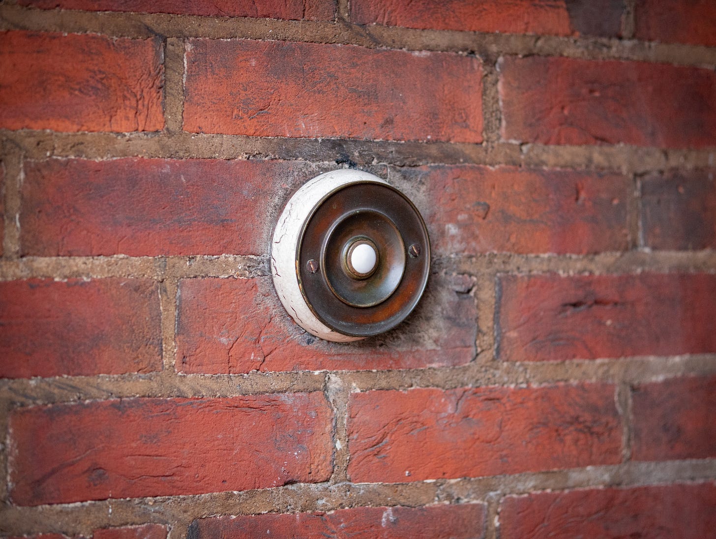 A photo of a doorbell on a brick wall