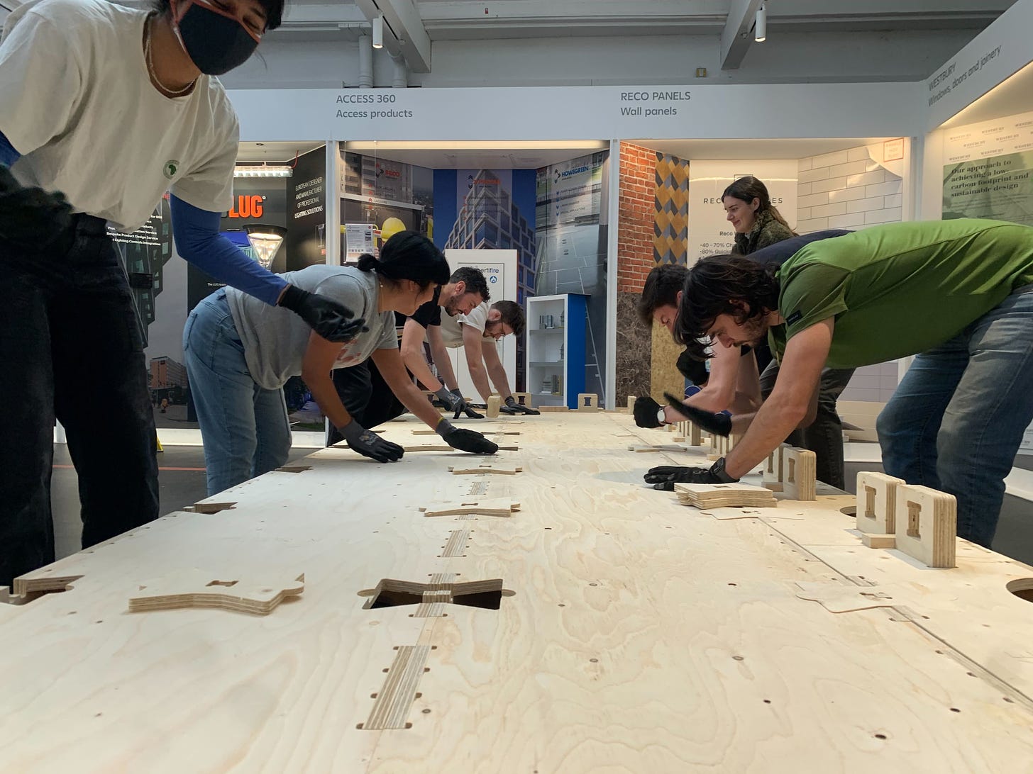 A team of people insert bowtie connectors on WikiHouse Skylark timber blocks