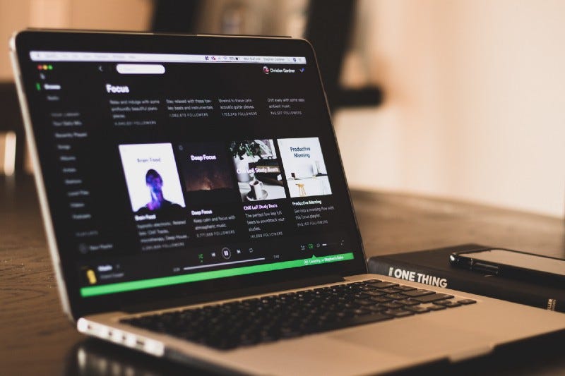An open laptop that shows the Spotify home page