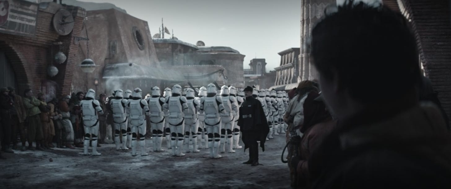 A formation of soldiers in Clone Trooper armor face away from the camera, while bystanders watch.