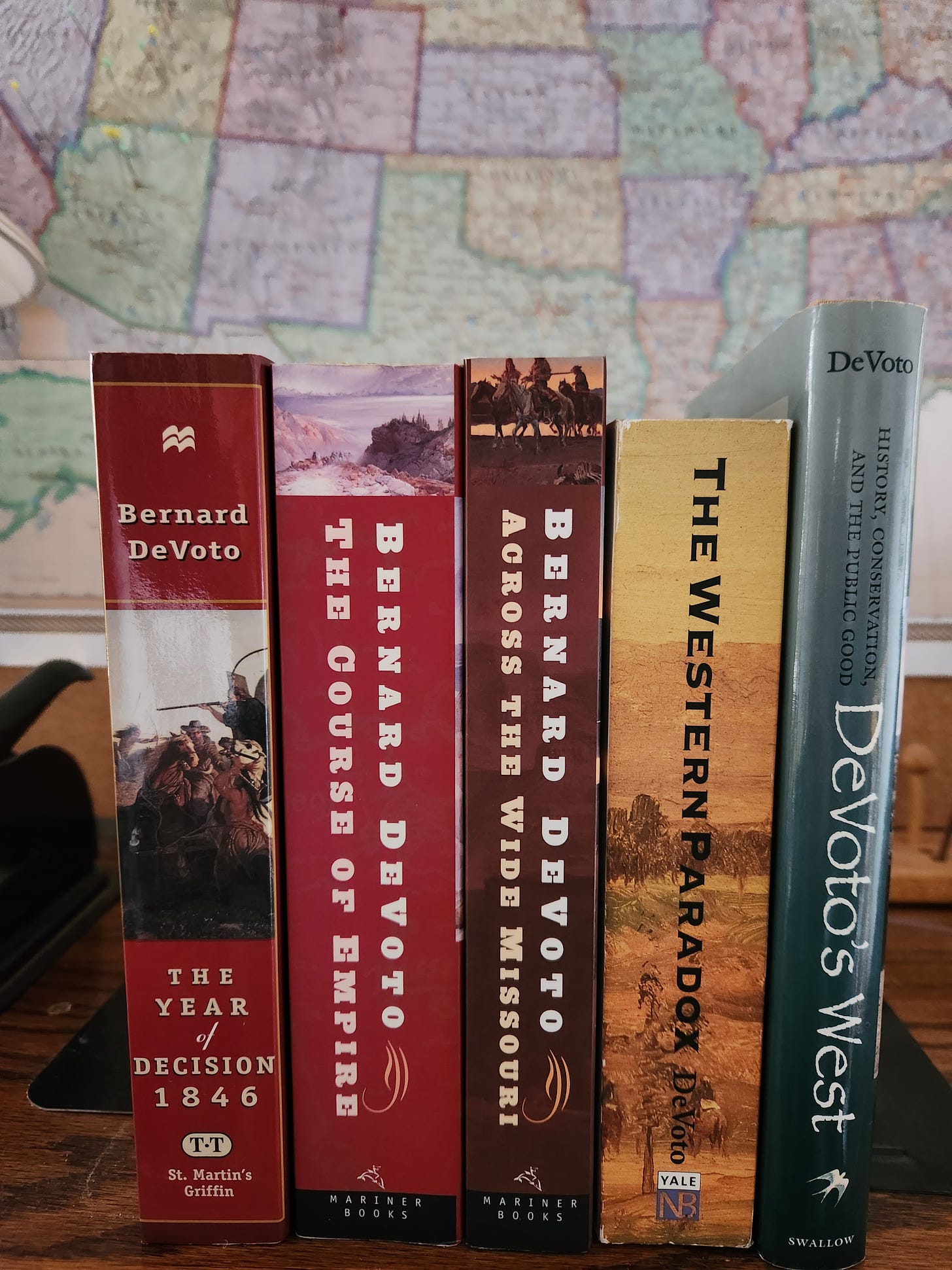 five books by DeVoto with a map of the US behind them
