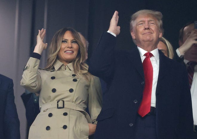 Melania Trump and Donald Trump do the tomahawk chop at Truist Park during Game 4 of the World Series.
