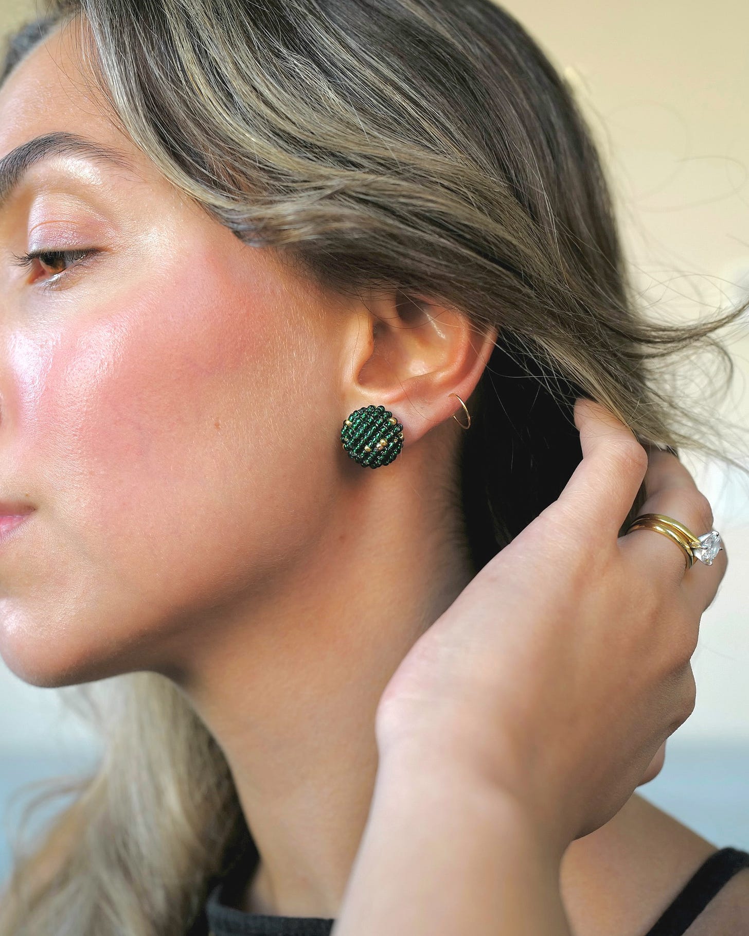 Emerald green earring being shown in close-up profile