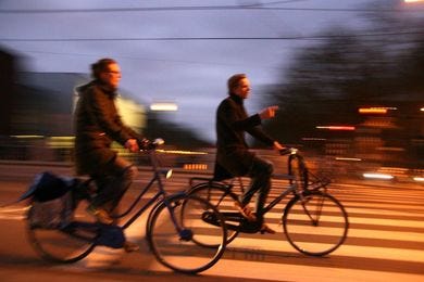 May be an image of one or more people, people riding bicycles, bicycle, street and road