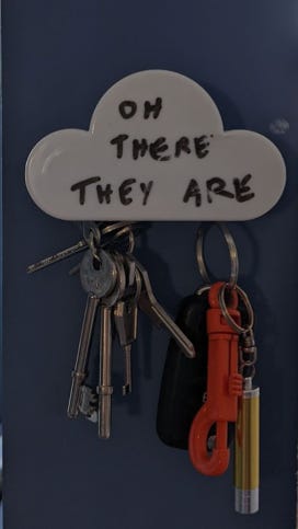 A photo of a magnetic key holder. "Oh there they are" is written on it.