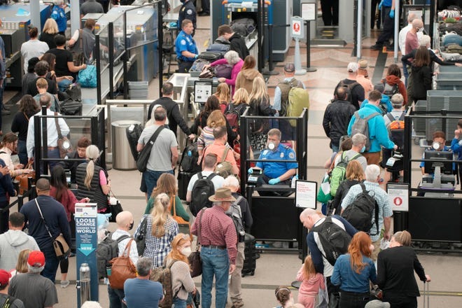 Travelers queue up move through the north security checkpoint in the main terminal of Denver International Airport, Thursday, May 26, 2022, in Denver.