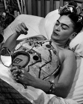Image of Frida Kahlo painting and examining her chest cast