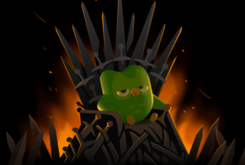 language learning app duolingo's mascot, a green bird named duo, appears sitting on the iron throne from the game of thrones HBO TV series based on the books by GRR Martin