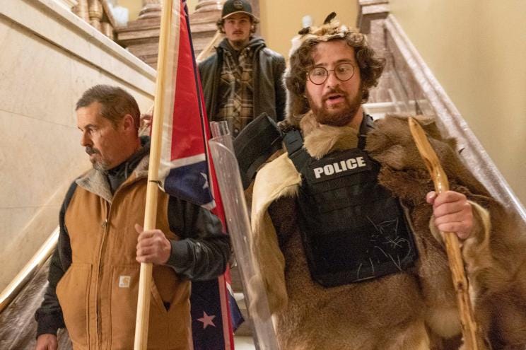 In this Jan. 6, 2021 file photo, supporters of President Donald Trump, including Aaron Mostofsky, right, who is identified in his arrest warrant, walk down the stairs outside the Senate Chamber in the U.S. Capitol, in Washington.