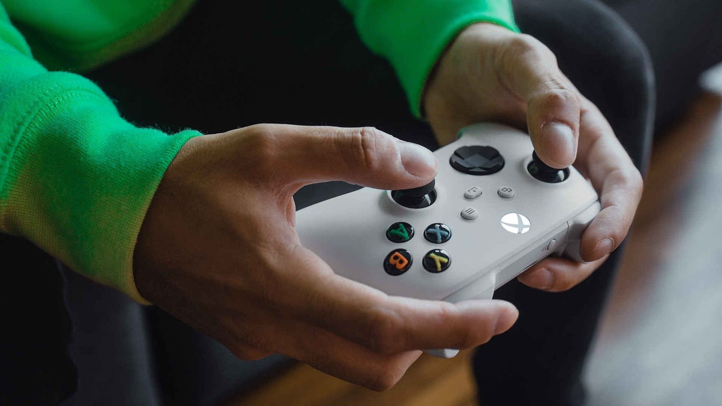 A man holding a white Xbox controller