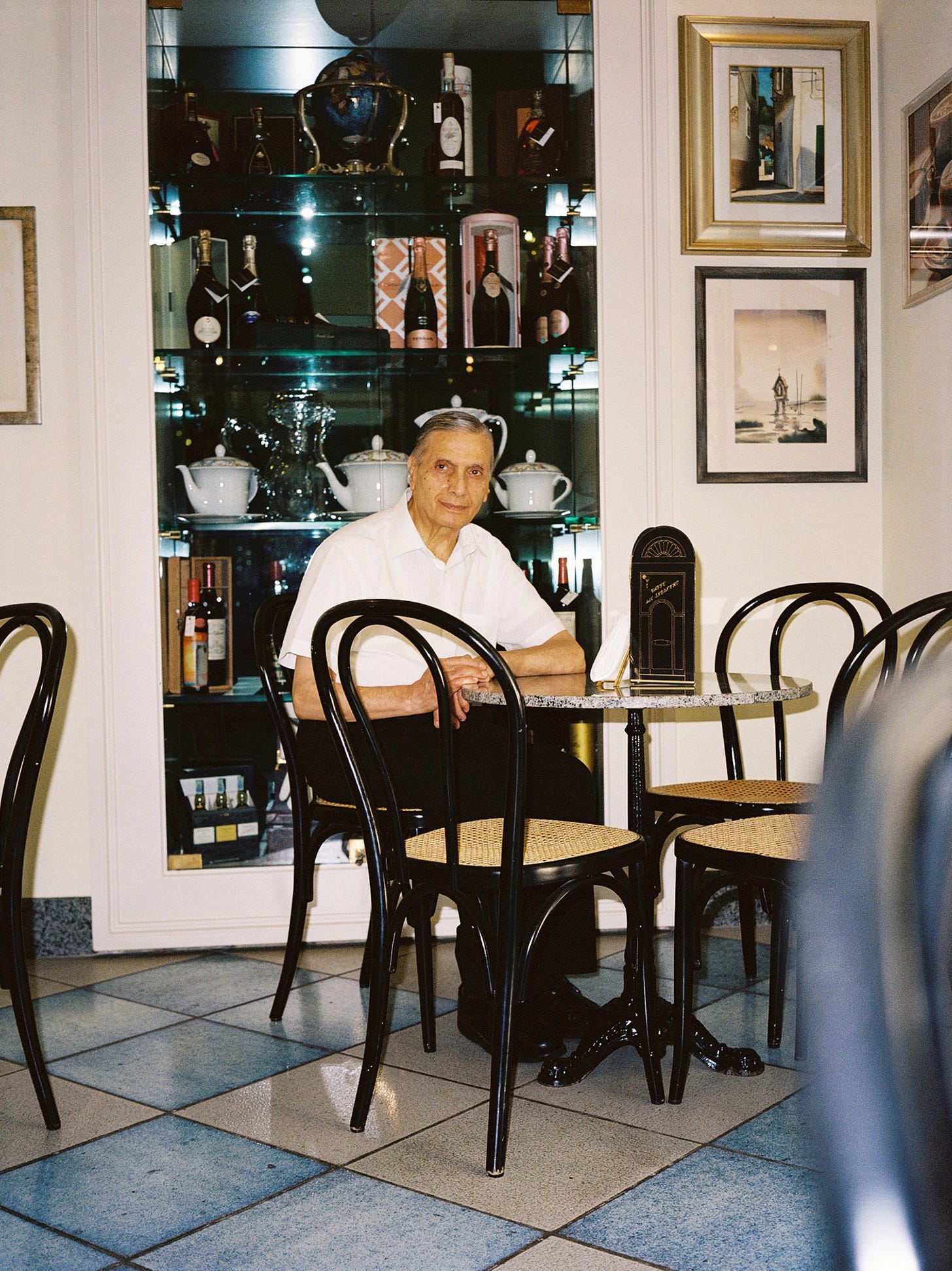 Franco Vitto, seduto su una sedia thonet nera nella saletta del Caffè dell'Incontro.
