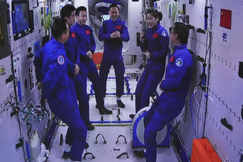 In this photo released by Xinhua News Agency, an image captured off a screen at the Jiuquan Satellite Launch Center in northwest China shows the Shenzhou-15 and Shenzhou-14 crew chatting after a historic gathering in space on Wednesday, Nov. 30, 2022. Three Chinese astronauts docked early Wednesday with their country's space station, where they will overlap for several days with the three-member crew already onboard and expand the facility to its maximum size. (Guo Zhongzheng/Xinhua via AP)