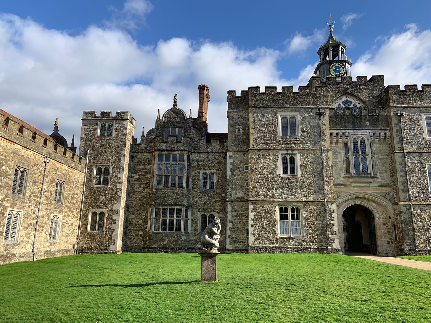 photo of the courtyard at Knole, including a grassy lawn with a nude sculpture of a woman, the English mansion sits behind it