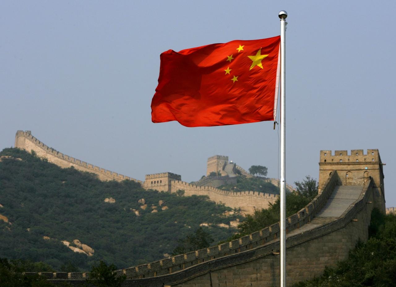 A Chinese flag flies in front of the Great Wall of China, located north of  Beijing - Egypt Independent