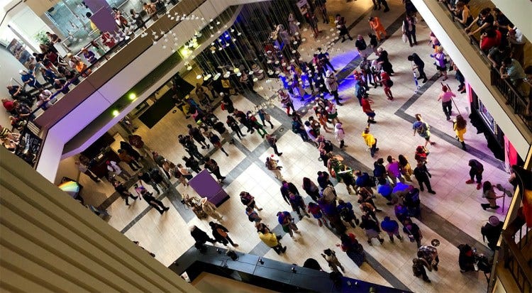 Photo looking down at a hotel lobby full of people at a convention