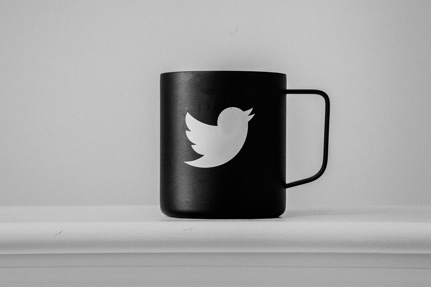 Photo of the Twitter logo on a coffee mug. (Edgar Moran / Unsplash)