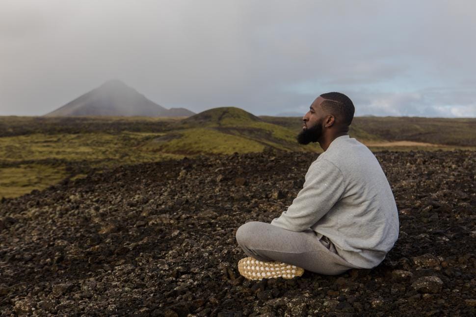 Free Stock Photo of Young Man in Grey Sweatshirt Sitting Alone Near  Mountains | Download Free Images and Free Illustrations