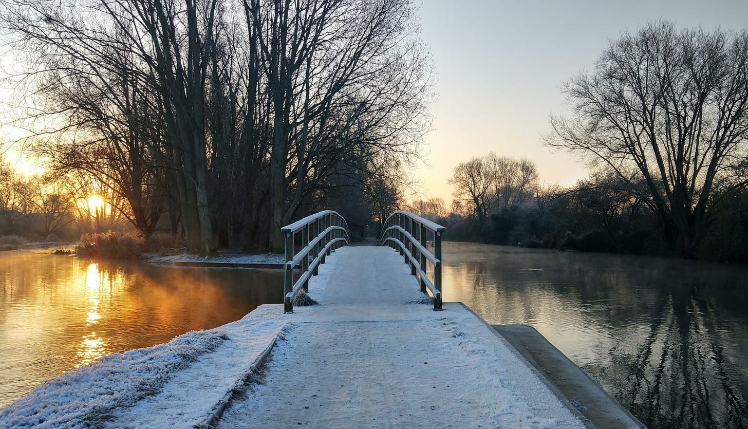 A frosty bridge over illuminated water