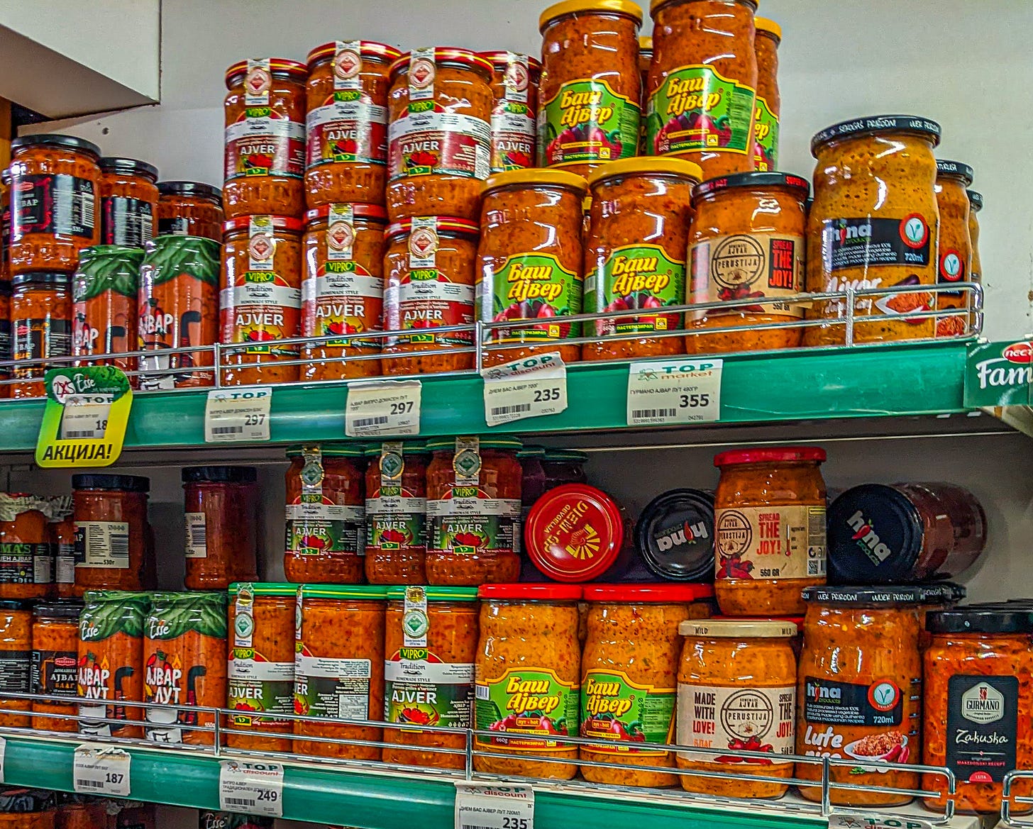 A photo showing grocery store shelves filled with jars of ajvar. 