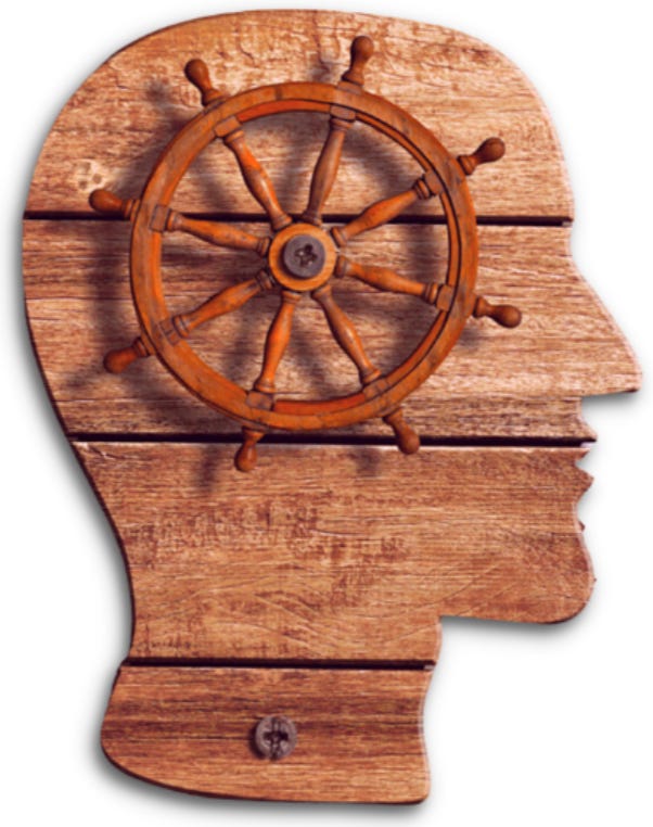 Wooden cutout of head with ships wheel attached to its center