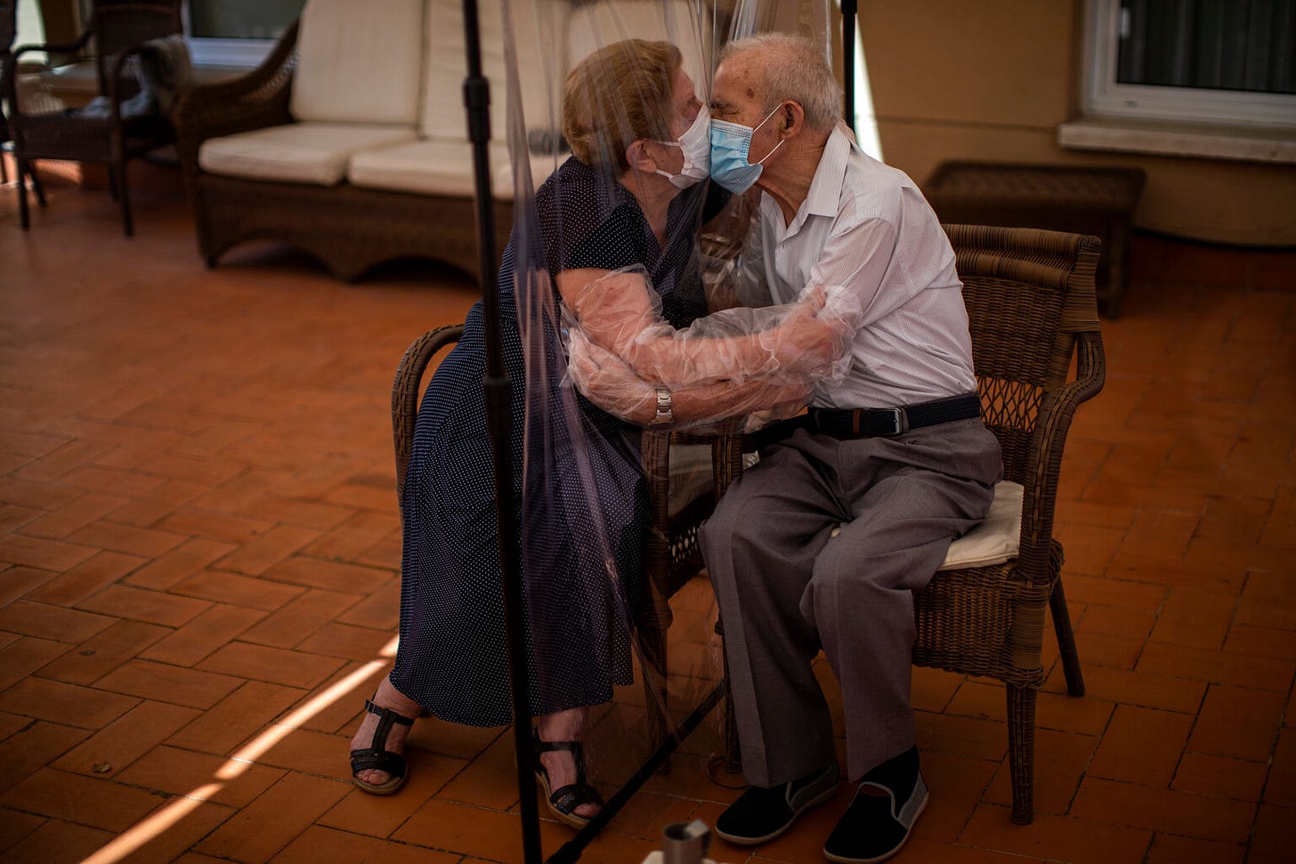 Agustina Cañamero, 81, and Pascual Pérez, 84, hug and kiss through a plastic film screen to avoid contracting the new coronavirus at a nursing home in Barcelona, Spain, June 22, 2020. (AP Photo/Emilio Morenatti)