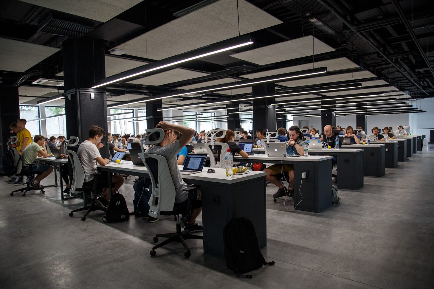 Image of people at work in an office for article titled “motivation to work in contemporary society”.