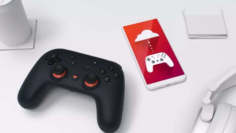 Google Stadia controller next a pair of headphones and a smartphone