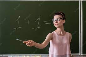 Jovem professora primária escrita no quadro-negro um mais um, conceito de  educação | Foto Premium