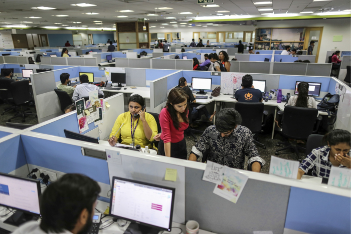 Indian workers sit at desks in an office 