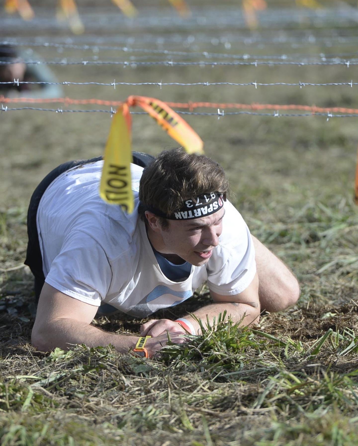 Army crawling under barbed wire at a Spartan Race.