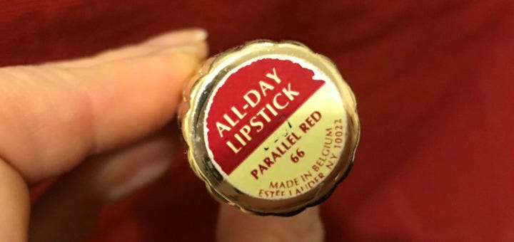 close up shot of the end of a lipstick tube that says ALL-DAY LIPSTICK PARALLEL RED 66