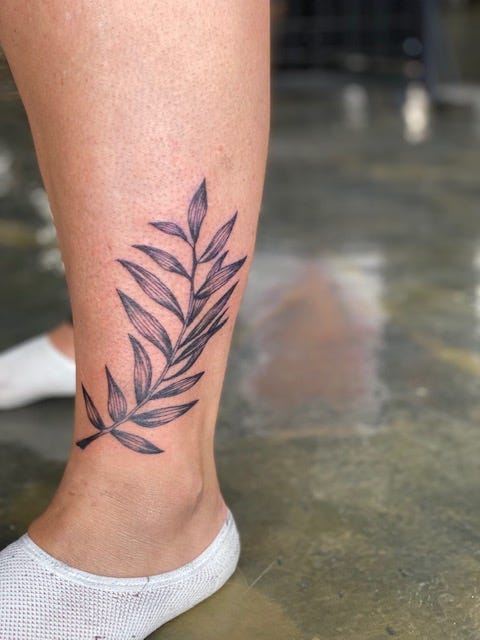A leaf tattoo on Roby's calf