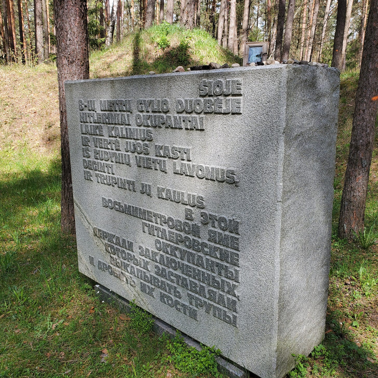 A stone block with writing in Lithuanian and Russian.