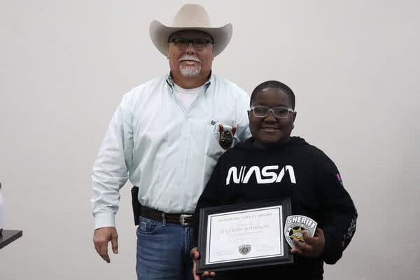 Davyon Johnson with Undersheriff Greg Martin of Muskogee County, Okla., after receiving an award for saving the lives of two people on the same day this month.