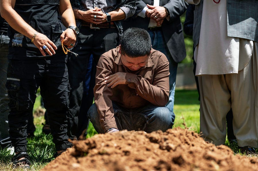 Altaf Hussein cries over the grave of his brother Aftab at Fairview Memorial Park in Albuquerque, N.M., on Aug. 5. A funeral service was held for Aftab Hussein, 41, and Muhammad Afzaal Hussain, 27, at the Islamic Center of New Mexico. Both men were fatally shot near their homes six days apart.