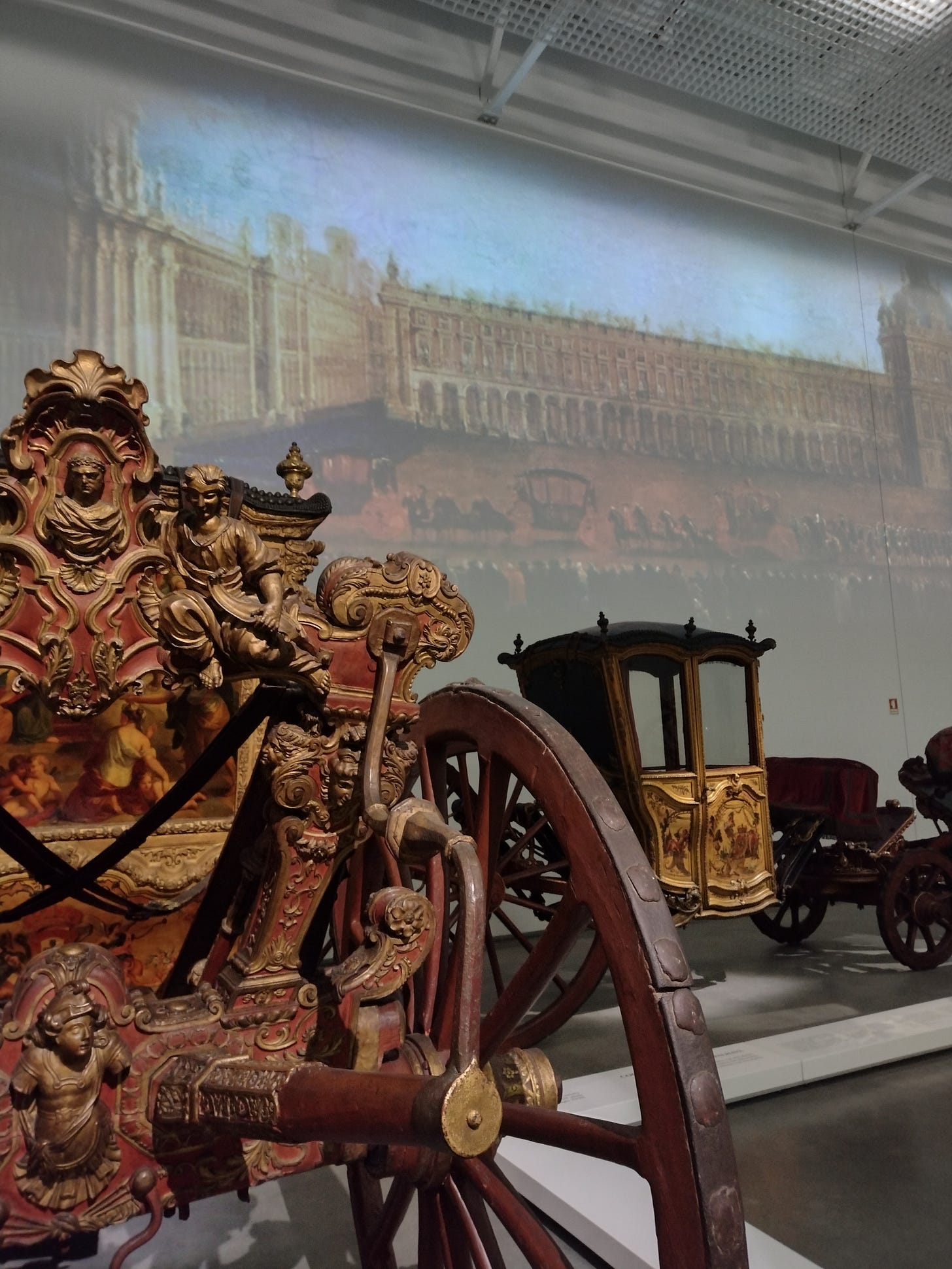 Ornate carriage with a video on the wall.